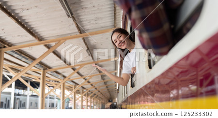 Journey and Travel. A joyful woman waving from a train, excited for her next adventure. Journey and Travel. A joyful woman waving from a train, excited for her next adventure. 125233302