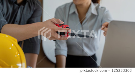 Communication and Coordination in Engineering. An engineer hands over a tool, fostering teamwork and connection in project execution. Communication and Coordination in Engineering. An engineer hands over a tool, fostering teamwork and connection in project execution. 125233303
