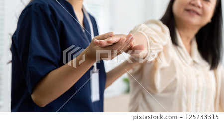Caregiver and Patient Interaction. A caregiver gently assists an elderly woman, showcasing compassion and health guidance. Caregiver and Patient Interaction. A caregiver gently assists an elderly woman, showcasing compassion and health guidance. 125233315