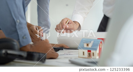 Team Discussion and Analysis. Professionals collaborating over construction designs while reviewing blueprints. Team Discussion and Analysis. Professionals collaborating over construction designs while reviewing blueprints. 125233396