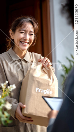cheerful courier delivering fragile package to customer at doorstep 125233670