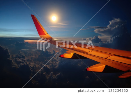 Serene Yet Powerful View of an Airfreight Plane Wing Above Majestic Clouds at Sunrise 125234360