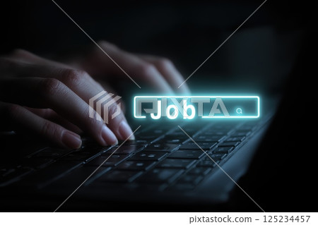 Hands Typing on Laptop with Job Search Bar Illuminated in Dark Environment 125234457