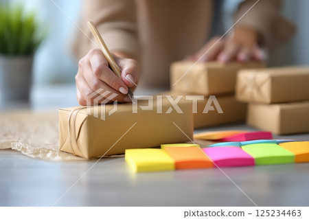 Hand Drawing Packaging Designs on Cardboard with Colorful Sticky Notes Nearby Hand Drawing Packaging Designs on Cardboard with Colorful Sticky Notes Nearby 125234463