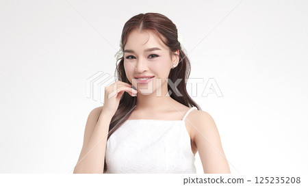 A beautiful young Asian woman with clean, fresh skin against a white background. Skincare, facial treatment, cosmetology, beauty, and spa. An elegant portrait of an Asian woman. A beautiful young Asian woman with clean, fresh skin against a white background. Skincare, facial treatment, cosmetology, beauty, and spa. An elegant portrait of an Asian woman. 125235208