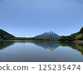 A tranquil early summer scene with Mt. Fuji reflected on the lake surface and blue skies. 125235474