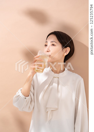 Woman drinking highball, sunlight Woman drinking highball, sunlight 125235794
