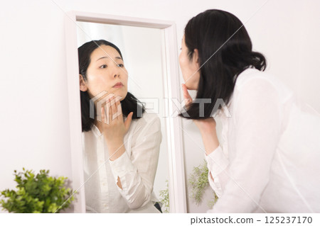 Middle-aged women who are concerned about age spots and fine lines 125237170