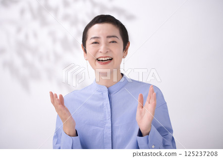 A middle-aged woman with short hair laughing loudly A middle-aged woman with short hair laughing loudly 125237208