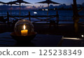 Ocean view terrace at dusk and bubble bowl with candles 125238349