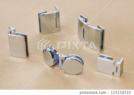variety of chrome glass hinges are laid variety of chrome glass hinges are laid 125238510