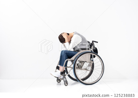 Worried woman in wheelchair, whole body 125238883