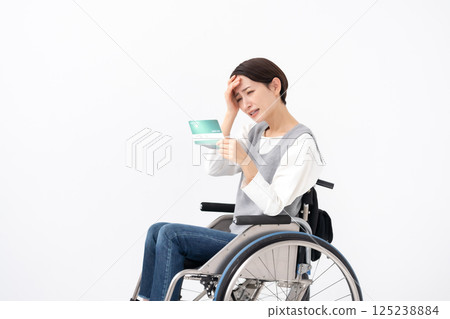 一位坐在輪椅上的女人看到自己的存摺時感到沮喪 125238884