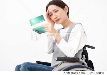 一位坐在輪椅上的女人看到自己的存摺時感到沮喪 125238891