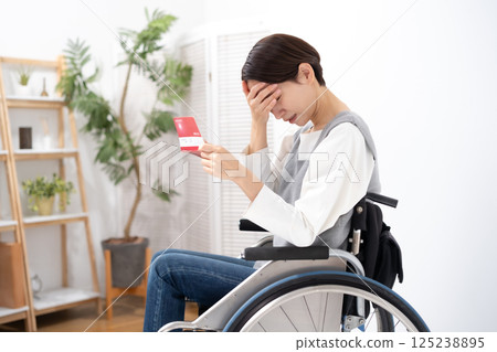 一位坐在輪椅上的女人看到自己的存摺時感到沮喪 125238895