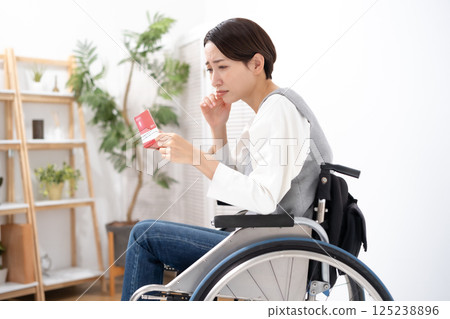 一位坐在輪椅上的女人看到自己的存摺時感到沮喪 一位坐在輪椅上的女人看到自己的存摺時感到沮喪 125238896