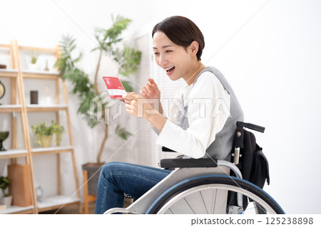 A woman in a wheelchair is happy to see her bankbook 125238898