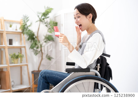 A woman in a wheelchair is happy to see her bankbook 125238900