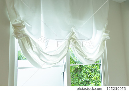 Beautiful elegant curtain close-up. Soft beige background as net curtains on the window. 125239053