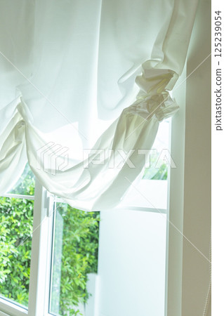 Beautiful elegant curtain close-up. Soft beige background as net curtains on the window. 125239054