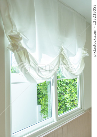 Beautiful elegant curtain close-up. Soft beige background as net curtains on the window. 125239055