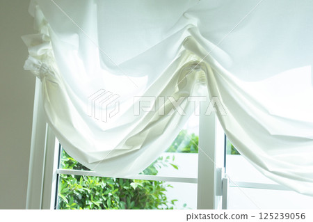 Beautiful elegant curtain close-up. Soft beige background as net curtains on the window. 125239056