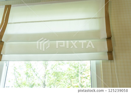 Beautiful elegant curtain close-up. Soft beige background as net curtains on the window. 125239058