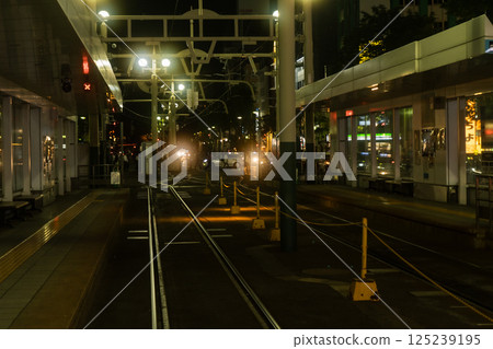 A freight train passing through a railroad crossing late at night 125239195