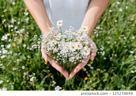 Wildflowers held in close up hands, evoking nature's connection and mindful wellness vibes 125239649
