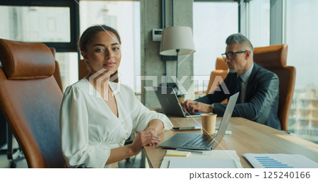 Businesswoman sitting confidently in office chair Businesswoman sitting confidently in office chair 125240166