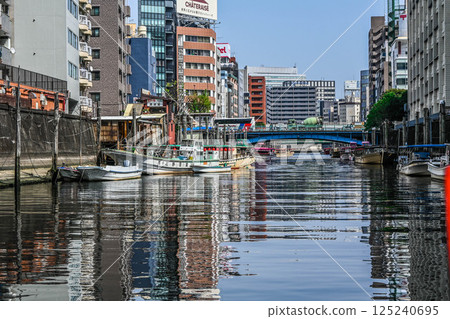 從神田川遊船上看到的景色:神田川上的船屋和船隻、堤岸和擁擠的建築物 從神田川遊船上看到的景色:神田川上的船屋和船隻、堤岸和擁擠的建築物 125240695