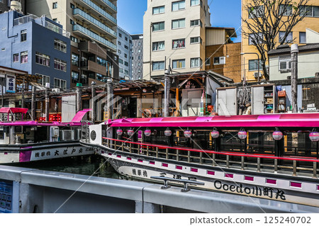 View from a Kanda River cruise ship: Boat lodges and boats on the Kanda River, embankments and crowded buildings 125240702