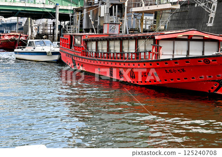 View from a Kanda River cruise ship: Boat lodges and boats on the Kanda River, embankments and crowded buildings 125240708