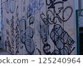 Graffitied white wall 125240964