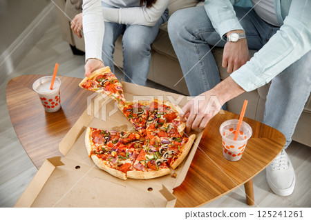 Colleagues eat pizza and chat. A snack break in the office. Business conversation of colleagues in a relaxed atmosphere 125241261