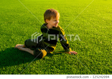 The child goes in for sports at the stadium. The boy training before playing football. 125242094
