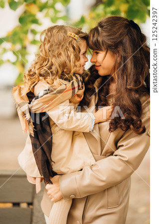 Joyful moment between mother and daughter in autumn park setting 125242397