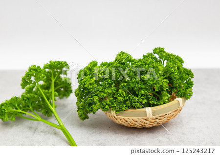 Parsley stock photo: Parsley on a white background in a small colander Parsley stock photo: Parsley on a white background in a small colander 125243217