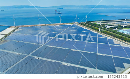 Aerial view of a hybrid power plant with wind turbines and solar panels Aerial view of a hybrid power plant with wind turbines and solar panels 125243513