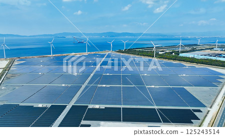 Aerial view of a hybrid power plant with wind turbines and solar panels 125243514