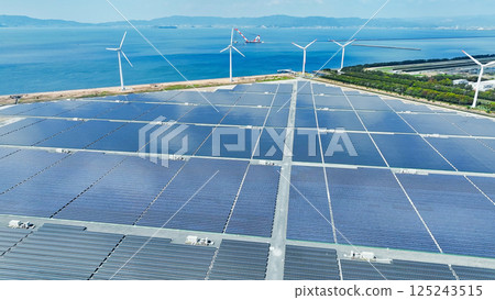 Aerial view of a hybrid power plant with wind turbines and solar panels 125243515