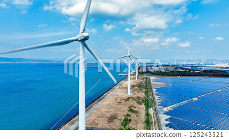 Aerial view of a hybrid power plant with wind turbines and solar panels 125243521