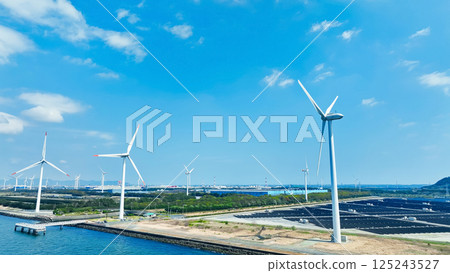 Aerial view of a hybrid power plant with wind turbines and solar panels Aerial view of a hybrid power plant with wind turbines and solar panels 125243527