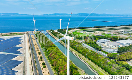 Aerial view of a hybrid power plant with wind turbines and solar panels Aerial view of a hybrid power plant with wind turbines and solar panels 125243577