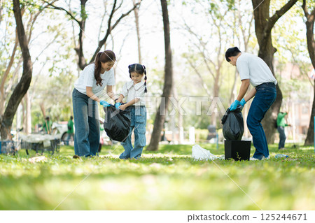 Happy Asian family collecting plastic bottles at the park. Happy Asian family collecting plastic bottles at the park. 125244671