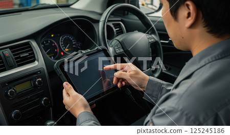 Mechanic diagnosing a car malfunction 125245186