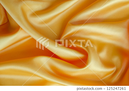 Golden yellow silk draped beautifully with glossy surface and soft highlights. Suitable for design and wallpaper background. Golden yellow silk draped beautifully with glossy surface and soft highlights. Suitable for design and wallpaper background. 125247261
