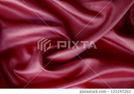 Dark red silk with soft curves and vibrant reflective surface. Suitable for design and wallpaper background. Dark red silk with soft curves and vibrant reflective surface. Suitable for design and wallpaper background. 125247262