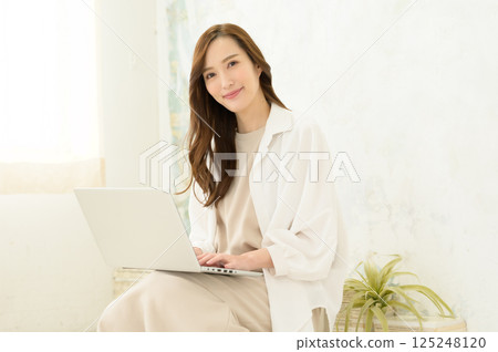 一位女士在膝蓋上操作筆記型電腦 一位女士在膝蓋上操作筆記型電腦 125248120