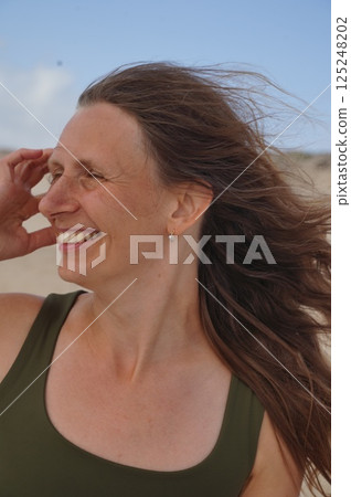 Woman Smiling with Hair Blowing in the Wind 125248202